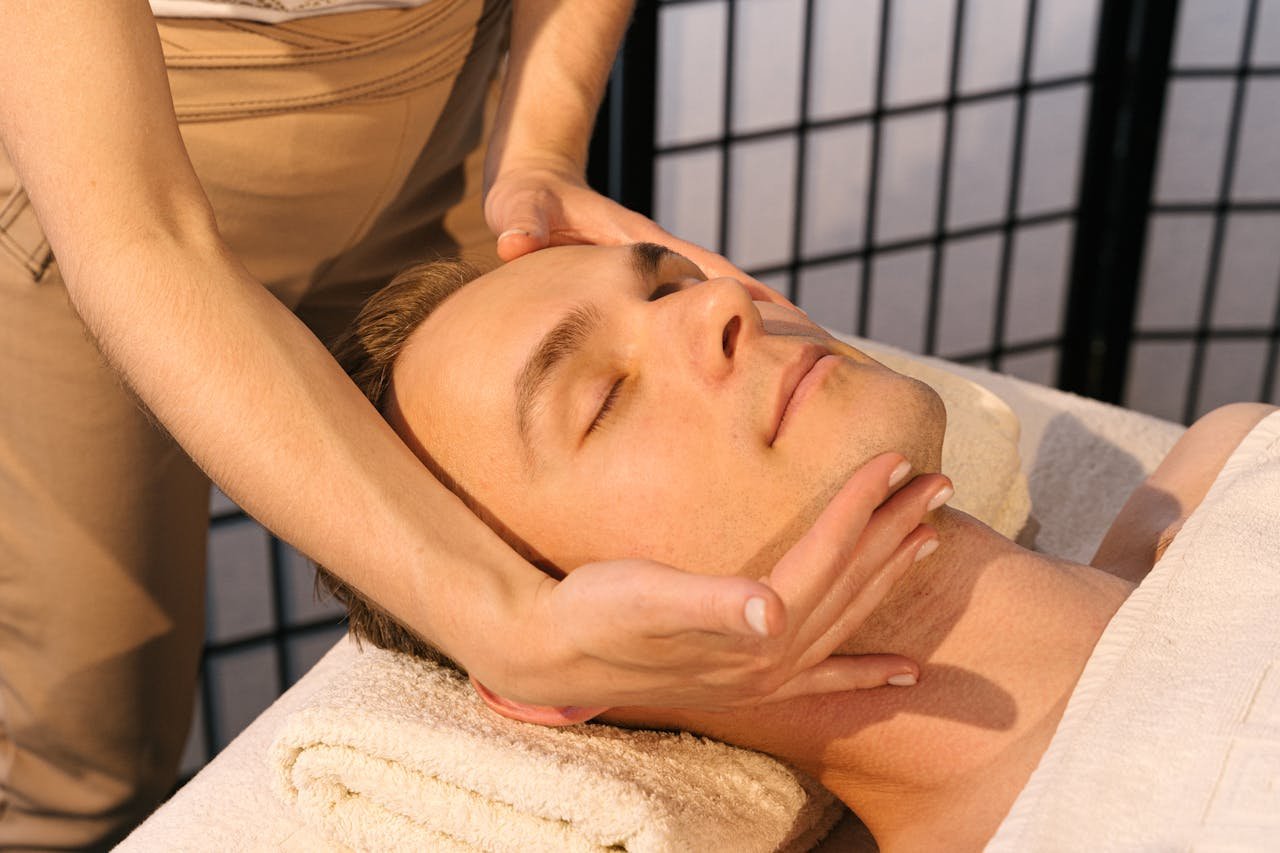 A Person Massaging a Man's Face